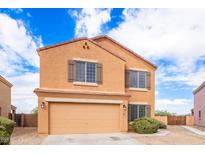 Two-story house with tan exterior and double garage at 18774 N Ibis Way, Maricopa, AZ 85138