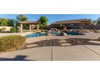 Inviting backyard pool with a waterfall and pergola at 9827 W Keyser Dr, Peoria, AZ 85383