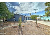 Ranch style home with desert landscaping and a large driveway at 3823 W Augusta Ave, Phoenix, AZ 85051