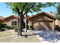Tan stucco house with tile roof, a two-car garage, and mature landscaping at 15626 N 50Th St, Scottsdale, AZ 85254