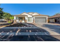 One-story home with gray garage door and stone accents at 3759 S Dew Drop Ln, Gilbert, AZ 85297