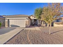 House exterior featuring a two-car garage and desert landscaping at 12806 W Charter Oak Rd, El Mirage, AZ 85335