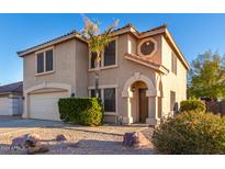 Two-story house with a tan stucco exterior and a two-car garage at 8143 E Obispo Ave, Mesa, AZ 85212