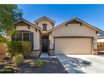 Single-story home with two-car garage and desert landscaping at 1952 N 212Th Ln, Buckeye, AZ 85396