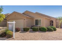 One-story house with beige exterior, landscaped front yard, and two-car garage at 17143 W Port Royale Ln, Surprise, AZ 85388