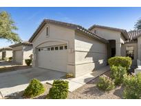 Tan house with a two-car garage and landscaping at 23817 S Harmony Way, Sun Lakes, AZ 85248