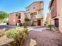 Two-story townhome with a walkway and landscaping at 1842 N 77Th Gln, Phoenix, AZ 85035