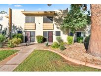 Two-story condo building exterior with landscaping and walkway at 4620 N 68Th St # 136, Scottsdale, AZ 85251