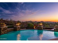 Luxury pool with fire features and mountain views at sunset at 42121 N Anthem Creek Dr, Anthem, AZ 85086