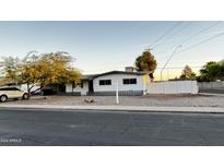 White single story house with a landscaped front yard and a white fence at 2207 E Aspen Ave, Mesa, AZ 85204