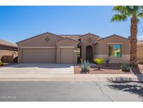 Tan two-story house with a three-car garage and desert landscaping at 42915 W Kingfisher Dr, Maricopa, AZ 85138