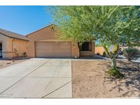 Tan house with a two-car garage and a nicely landscaped front yard at 2276 N Hudson Dr, Florence, AZ 85132