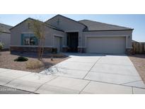 House exterior with a two-car garage and landscaped yard at 30893 W Pinchot W Ct, Buckeye, AZ 85396