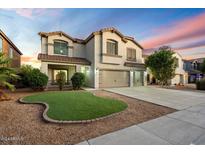 Two-story house with artificial turf front yard at 15163 W Cameron Dr, Surprise, AZ 85379