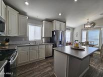 Modern kitchen with island, stainless steel appliances, and light cabinets at 650 N Hawes Rd # 3314, Mesa, AZ 85207