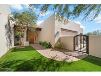 Landscaped front yard with artificial turf and brick path at 14428 E Monument Dr, Scottsdale, AZ 85262