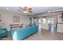Open living room with teal sofa and modern kitchen at 7544 E Mckinley St, Scottsdale, AZ 85257