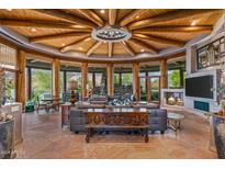 Spacious living room with a circular wooden ceiling, stone floor, and large windows at 40523 N 102Nd Pl, Scottsdale, AZ 85262