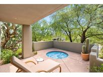 Relaxing patio with spa, lounge chair, and desert landscaping at 10044 E Graythorn Dr, Scottsdale, AZ 85262