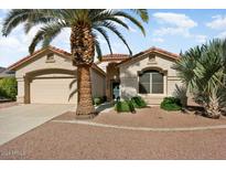 Single-story home with a tan exterior and palm trees at 17828 W Mariposa Dr, Surprise, AZ 85374