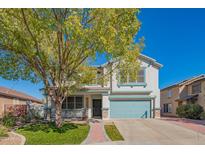 Two story house with teal garage door and manicured lawn at 17186 W Post Dr, Surprise, AZ 85388