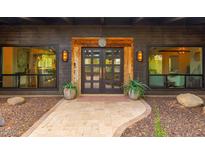 Inviting entryway with double wood doors, stone pathway, and landscaping at 35026 N 84Th St, Scottsdale, AZ 85266