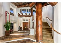 Grand entryway with a unique staircase, wood beams, and flagstone flooring at 8599 E Tecolote Cir, Scottsdale, AZ 85266