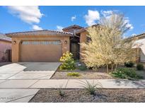 Tan house with tile roof, two-car garage, and landscaping at 23075 E Orion Way, Queen Creek, AZ 85142