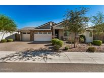 Single-story home with a three-car garage and landscaping at 12221 E Chiricahua Pl, Gold Canyon, AZ 85118