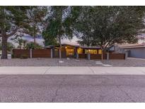 Mid-century modern home with wood fence, gravel landscaping and walkway at 8325 E Crestwood Way, Scottsdale, AZ 85250