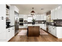 Spacious kitchen with white cabinets, a large island, and hardwood floors at 88 N Country Club Dr, Phoenix, AZ 85014
