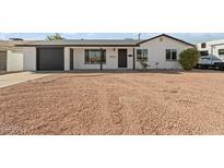 Newly remodeled home with a white exterior and dark gray garage door at 5714 N 19Th Dr, Phoenix, AZ 85015