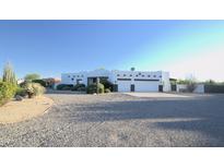 White stucco house with a three-car garage and desert landscaping at 27824 N 256Th Ave, Wittmann, AZ 85361