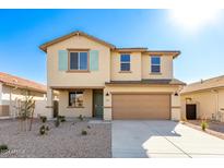 Two-story house with tan exterior, light green shutters, and a two-car garage at 7499 E Sweet Honey Ln, San Tan Valley, AZ 85143