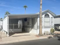 White manufactured home with carport and desert landscaping at 225 S Motherlode Dr, Apache Junction, AZ 85119