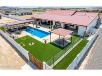 Aerial view of house, pool, and backyard with artificial turf and pergola at 5604 S 225Th Ave, Buckeye, AZ 85326
