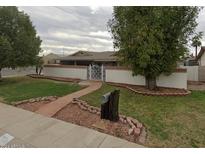 House exterior showcasing a walkway, gate and well manicured lawn at 3501 W Lupine Ave, Phoenix, AZ 85029