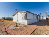 Single-wide manufactured home with a landscaped yard and walkway at 530 S 98Th Way, Mesa, AZ 85208