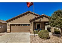 Tan house with two-car garage and landscaped yard at 22608 W Gardenia Dr, Buckeye, AZ 85326