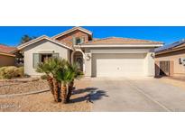 House exterior with a two-car garage and desert landscaping at 980 S 220Th Ln, Buckeye, AZ 85326