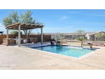 Inviting backyard oasis featuring a sparkling pool, built-in barbecue, and pergola at 16918 S 180Th Dr, Goodyear, AZ 85338