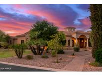 Lovely home with palm trees and a brick walkway at sunset at 2300 E Sanoque Ct, Gilbert, AZ 85298