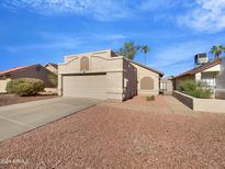 Tan stucco house with a two-car garage and landscaped yard at 1114 W Estrella Dr, Chandler, AZ 85224