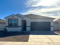 Newly constructed single-story home with a two-car garage and desert landscaping at 1523 E Lardner Dr, Casa Grande, AZ 85122