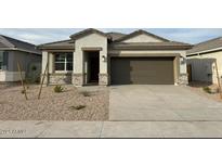 Newly built home with stone accents and a two-car garage at 38120 W Excussare Way, Maricopa, AZ 85138