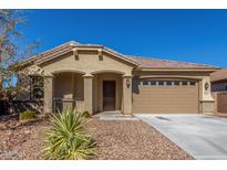 Tan two-car garage home with desert landscaping at 43958 W Stonecreek Rd, Maricopa, AZ 85139