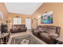 Living room with vaulted ceiling, tile floor, and brown sofas at 455 S Delaware Dr # 124, Apache Junction, AZ 85120