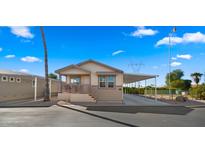 Tan manufactured home with carport and landscaping at 9333 E University Dr # 45, Mesa, AZ 85207