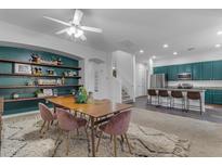 Open concept dining area with a long wooden table and pink chairs at 964 W Saguaro Ln, San Tan Valley, AZ 85143