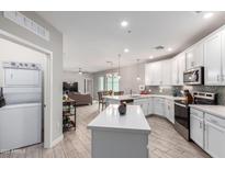 Modern kitchen with white cabinets, island, and stainless steel appliances at 2511 W Queen Creek Rd # 205, Chandler, AZ 85248